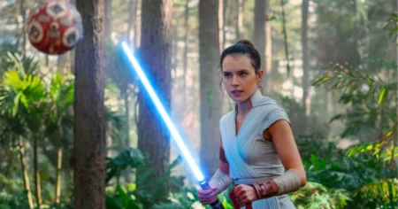 Star Wars prepara nova trilogia com diretor de Homem-Aranha; veja Mulher segura sabre de luz azul em cenário de floresta em cena da franquia Star Wars
